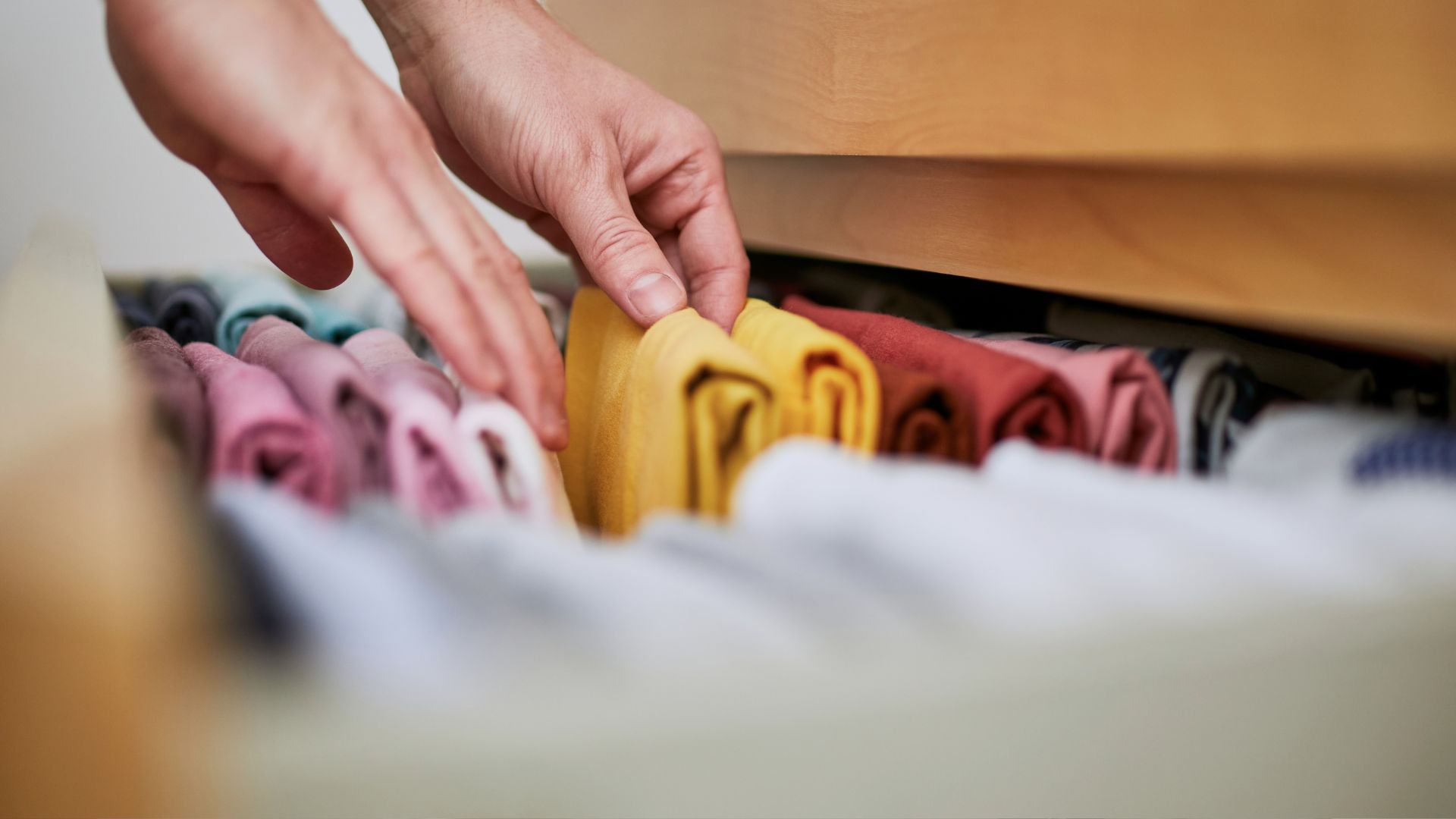 A person reaching for a cloth in a closet